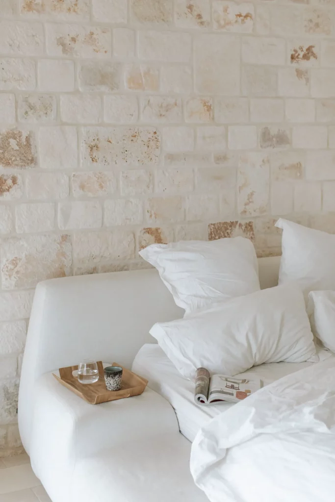 grand lit blanc près de la pierre blanche du mur