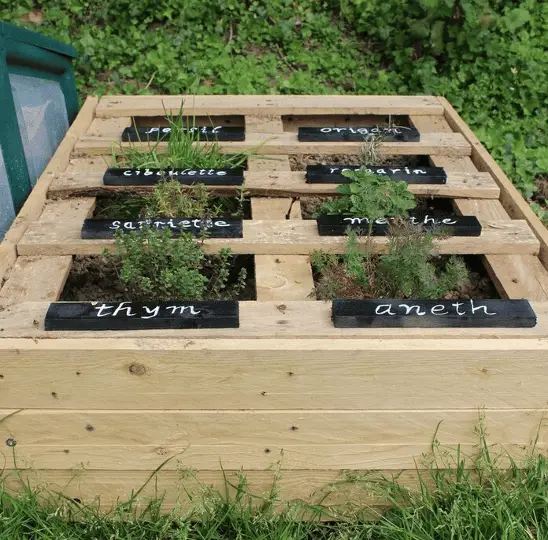 Une palette rehaussée avec d’autres bouts de palettes pour créer un mini potager