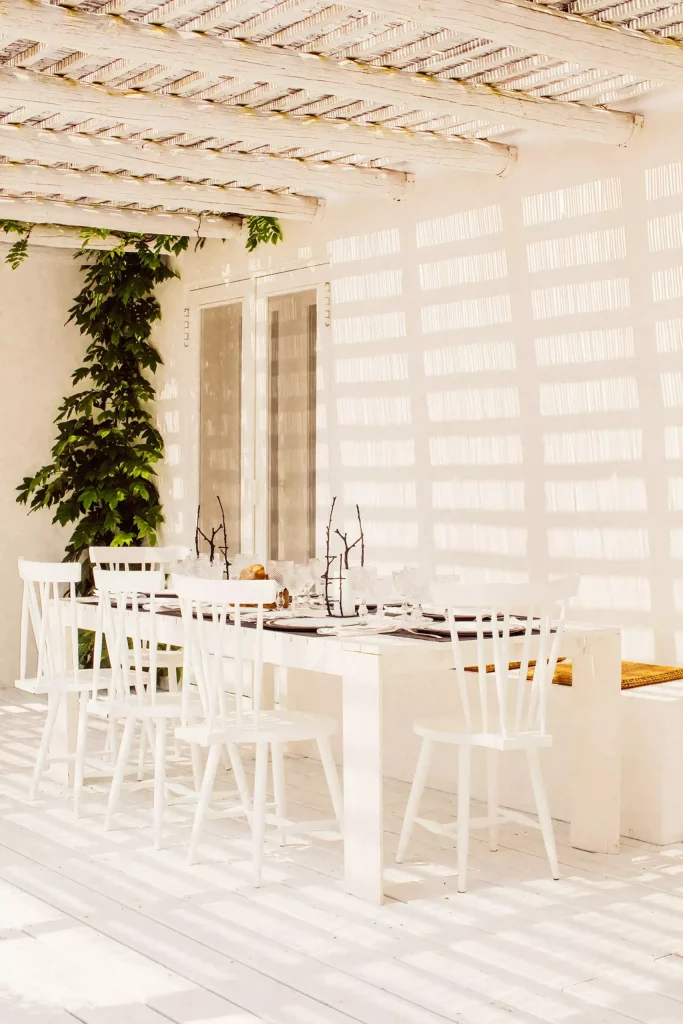 grande table en bois blanc sous la pergola