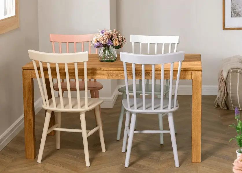 Une petite salle à manger et ses jolies chaises en bois aux teintes pastel