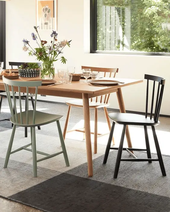 Une chaise verte, une noire et une en bois pour une salle à manger raffinée