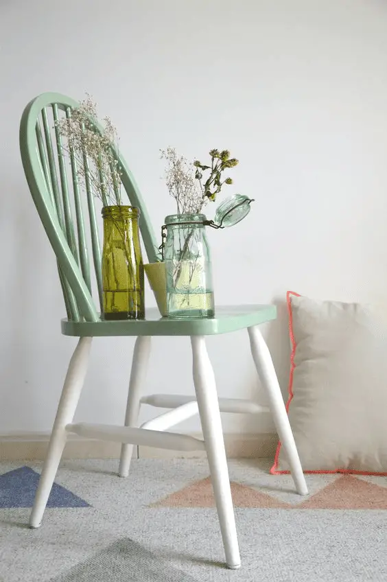 Une chaise bicolore peinte avec de la peinture verte et blanche