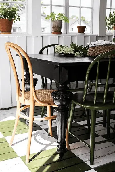 Une table noire, une chaise vert kaki, une autre en bois pour donner un style élégant et original à son coin cuisine
