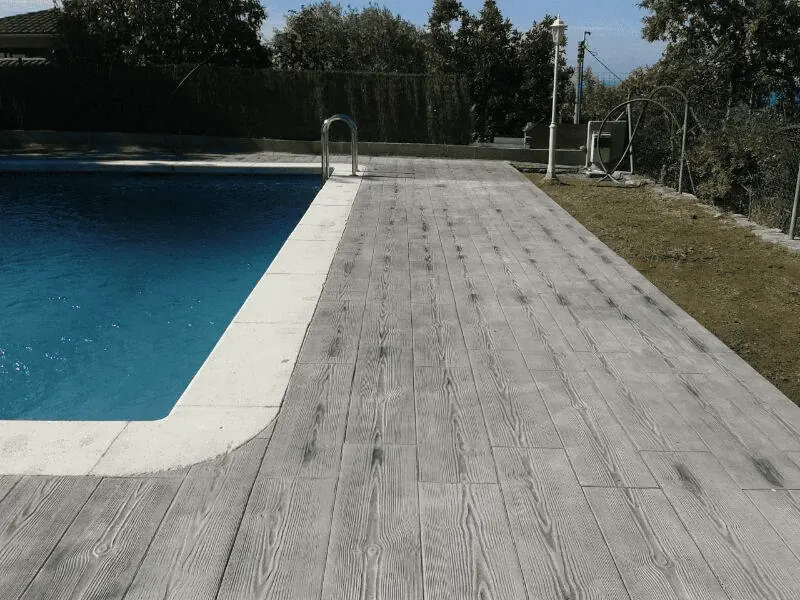 Le contour de la piscine est ici composé d’un mix carrelage-béton imprimé