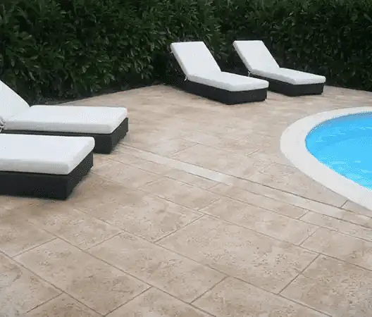Un très beau sol en béton imprimé, imitation pierre, au bord de la piscine