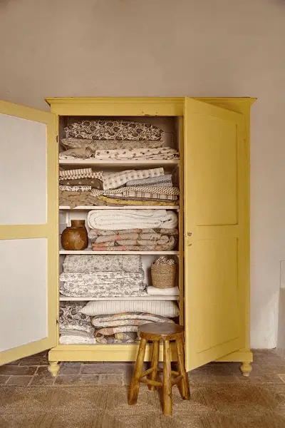 Pour cette armoire jaune, seulement l'intérieur des portes a été peint en blanc cassé