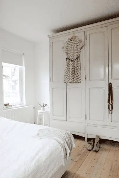 Une grande armoire en bois massif peinte en blanc dans la chambre conjugale