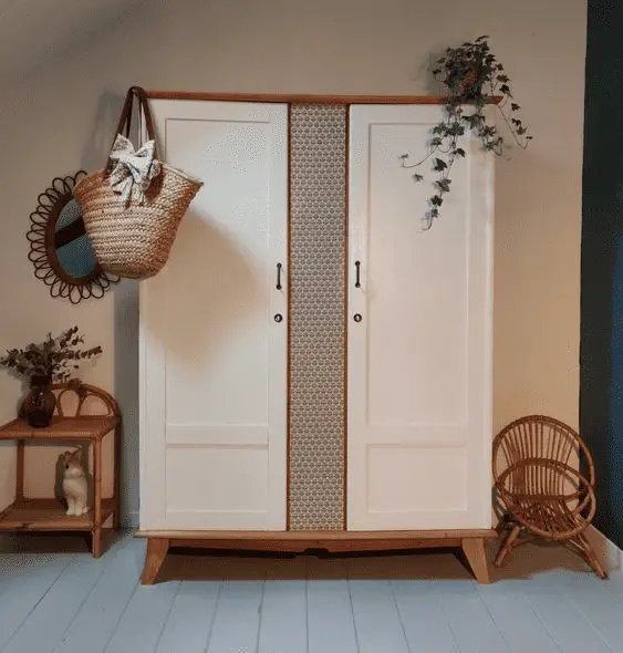 Du papier peint à motifs géométriques entre les deux portes pour cette armoire en bois vintage