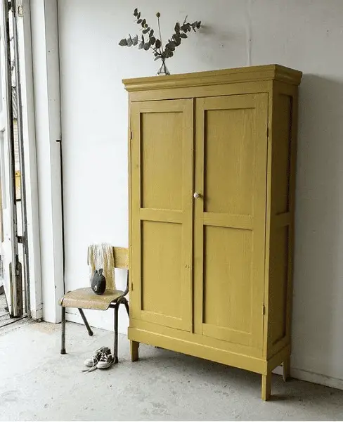 Une armoire parisienne revue dans une couleur moutarde pour décorer l'entrée