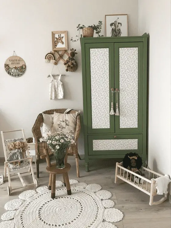 De la tapisserie sur les portes de cette petite armoire en bois aménagée dans une chambre d'enfant
