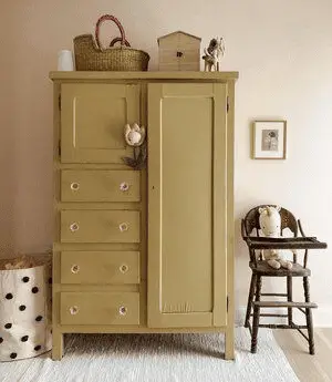 Une armoire en bois vintage rénovée en jaune moutarde pour une chambre d'enfant