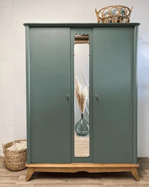 Une armoire vintage peinte dans un vert-gris avec la conservation des pieds compas en bois massif